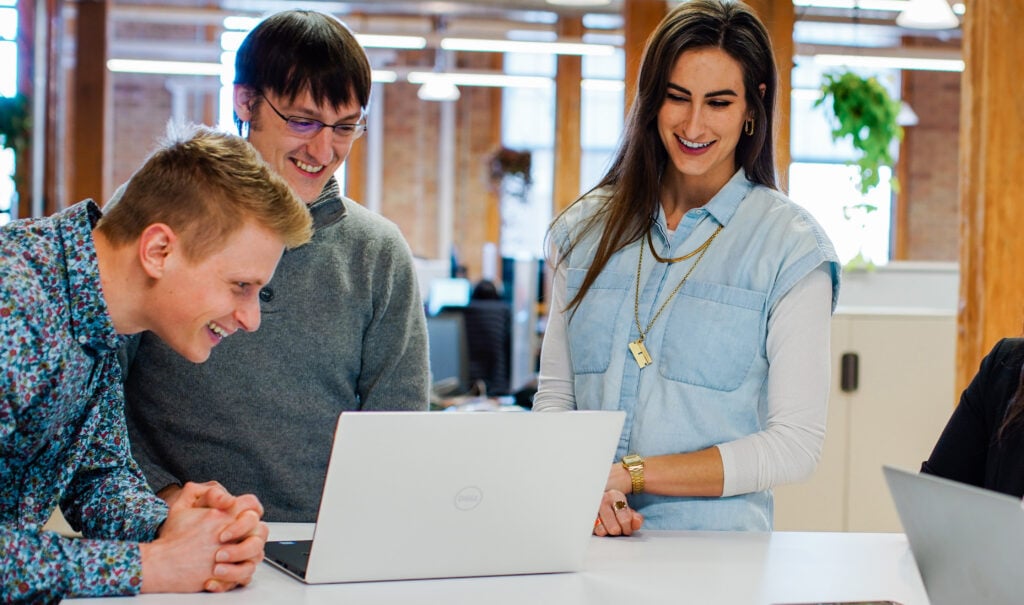 a group of people looking at a laptop